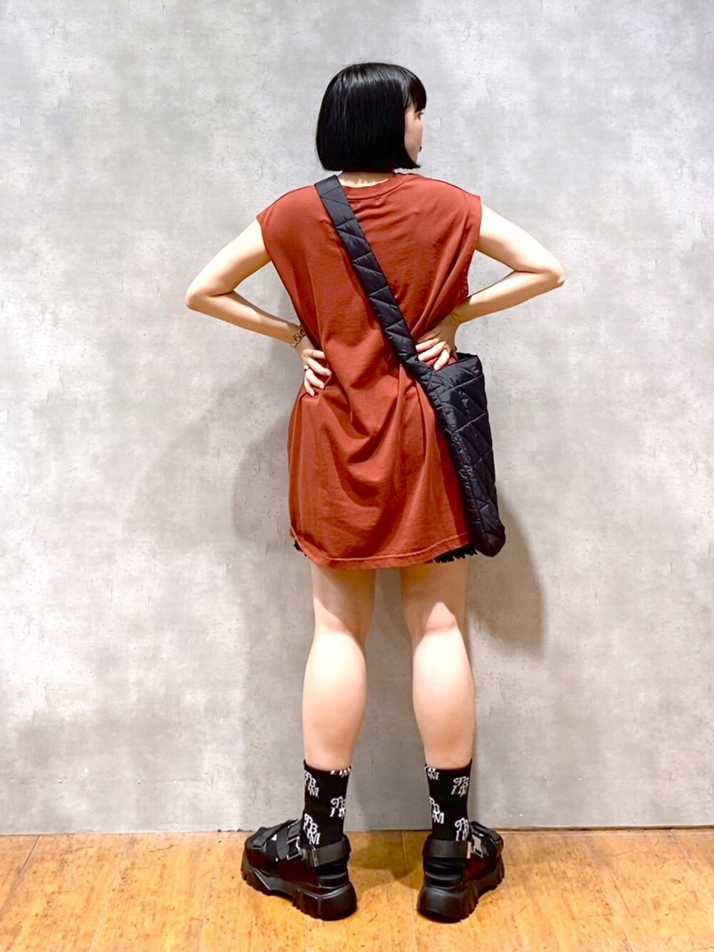 レッド系のTシャツ/カットソー、ブラック系のショルダーバッグ、ブラック系のその他パンツを着用したレディースの夏コーディネートの3枚目の写真