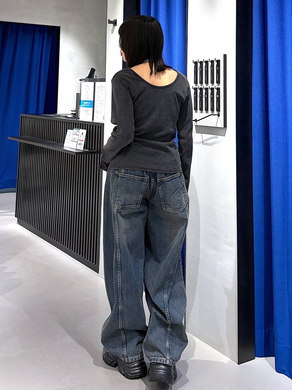 ブラック系のブーツ、ブルー系のデニムパンツ、グレー系のTシャツ/カットソーを着用したレディースの春コーディネートの6枚目の写真