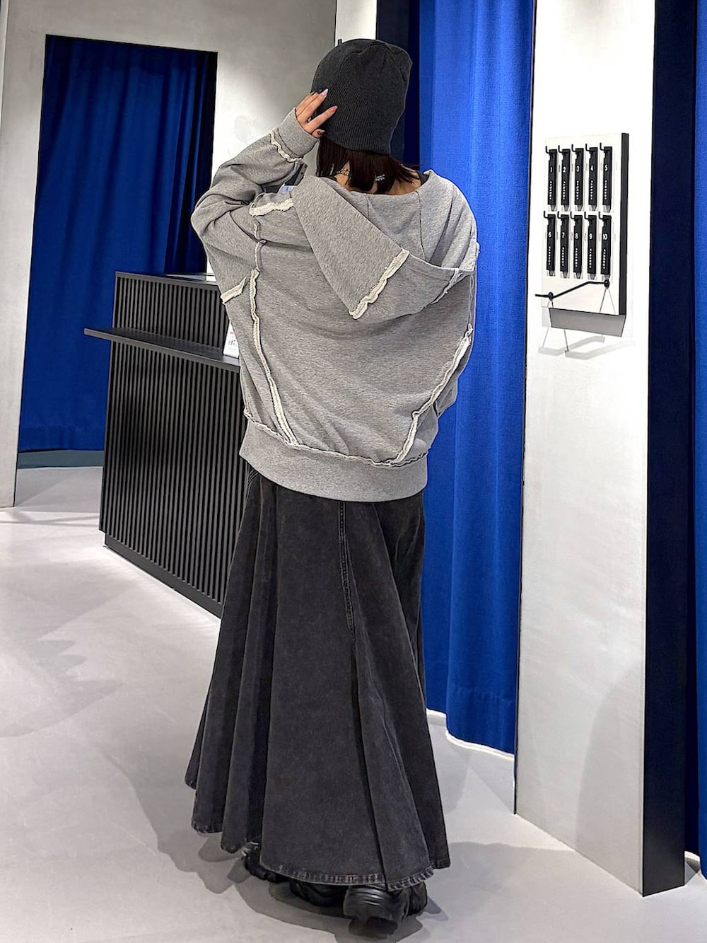 ブラック系のスニーカー、ブラック系のデニムスカート、グレー系のタンクトップを着用したレディースの春コーディネートの3枚目の写真