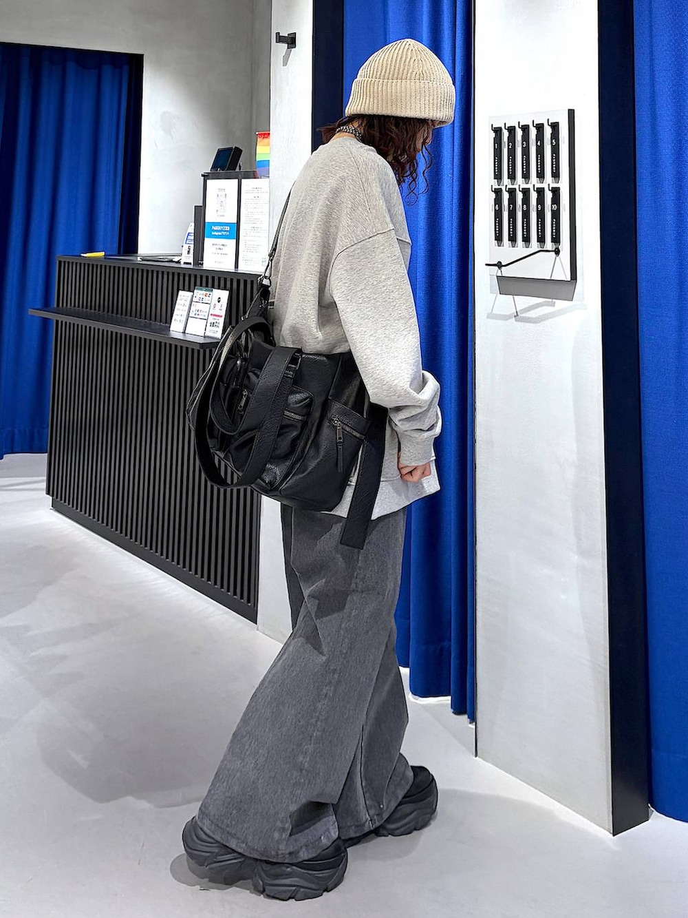 ブラック系のブーツ、ブラック系のボストンバッグ、ブラック系のデニムパンツを着用したレディースの冬コーディネートの2枚目の写真