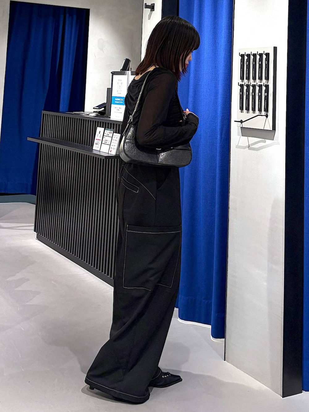 ブラック系のキャミソール、ブラック系のハンドバッグ、ブラック系のサンダルを着用したレディースの春コーディネートの2枚目の写真