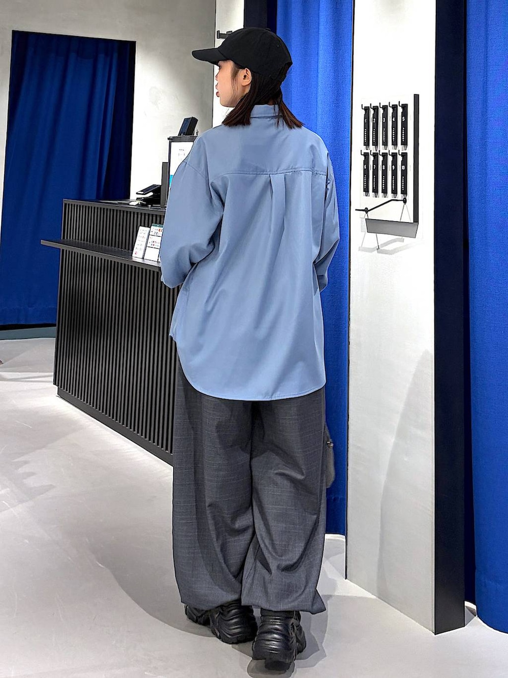 ブラック系のスニーカー、ブラック系のボストンバッグ、グレー系のその他パンツを着用したレディースの冬コーディネートの3枚目の写真