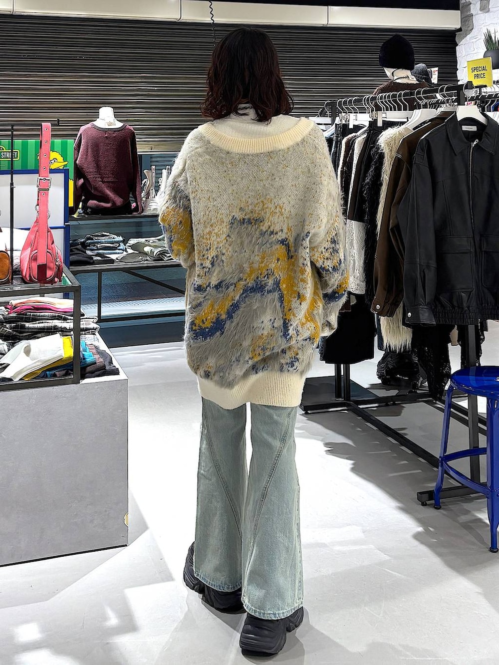 ブラック系のブーツ、ブルー系のデニムパンツ、ホワイト系のカーディガン/ボレロを着用したレディースの冬コーディネートの3枚目の写真