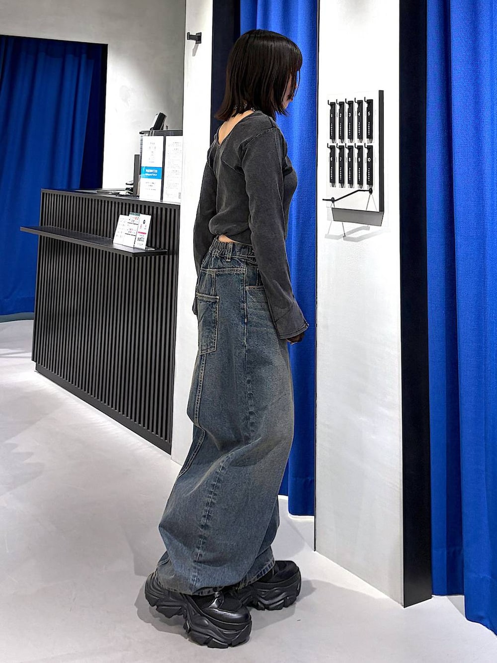 ブラック系のブーツ、ブルー系のデニムパンツ、グレー系のTシャツ/カットソーを着用したレディースの春コーディネートの2枚目の写真