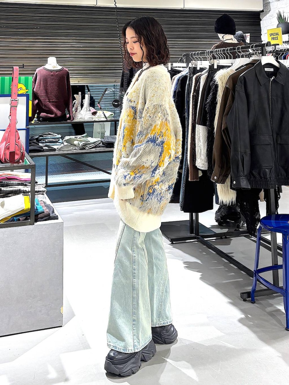 ブラック系のブーツ、ブルー系のデニムパンツ、ホワイト系のカーディガン/ボレロを着用したレディースの冬コーディネートの4枚目の写真