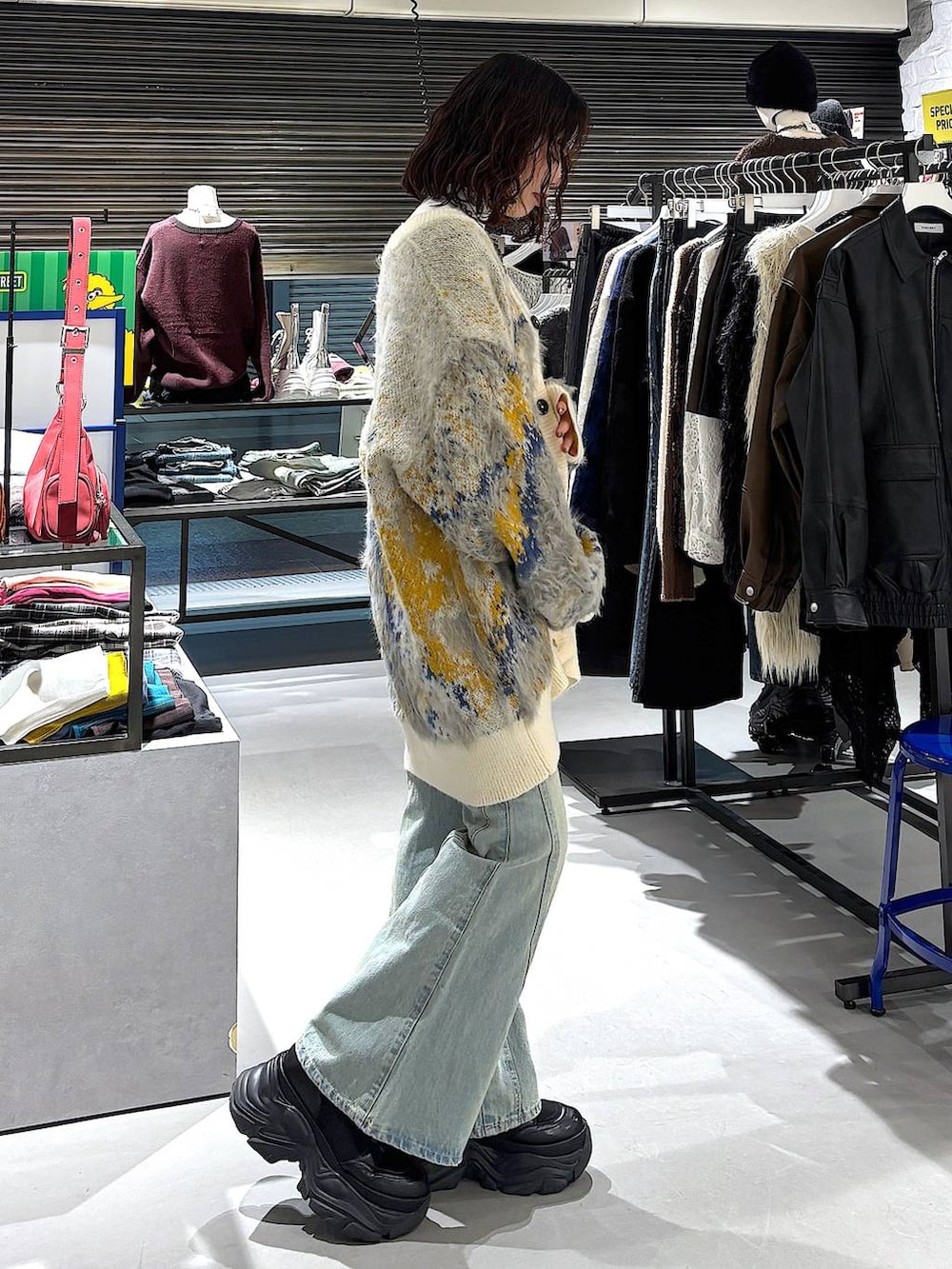 ブラック系のブーツ、ブルー系のデニムパンツ、ホワイト系のカーディガン/ボレロを着用したレディースの冬コーディネートの2枚目の写真