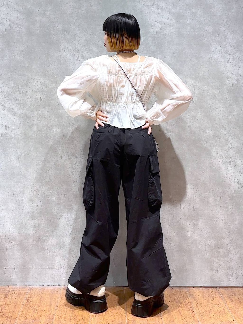 ブラック系のカーゴパンツ、ホワイト系のシャツ/ブラウス、ブラック系のキャミソールを着用したレディースの春コーディネートの3枚目の写真