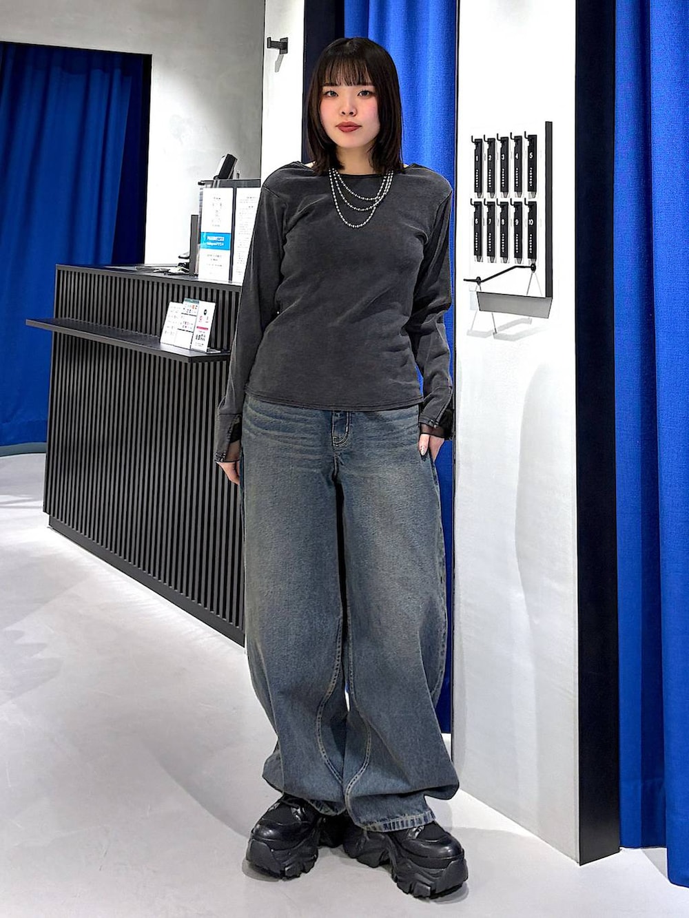 ブラック系のブーツ、ブルー系のデニムパンツ、グレー系のTシャツ/カットソーを着用したレディースの春コーディネートの5枚目の写真