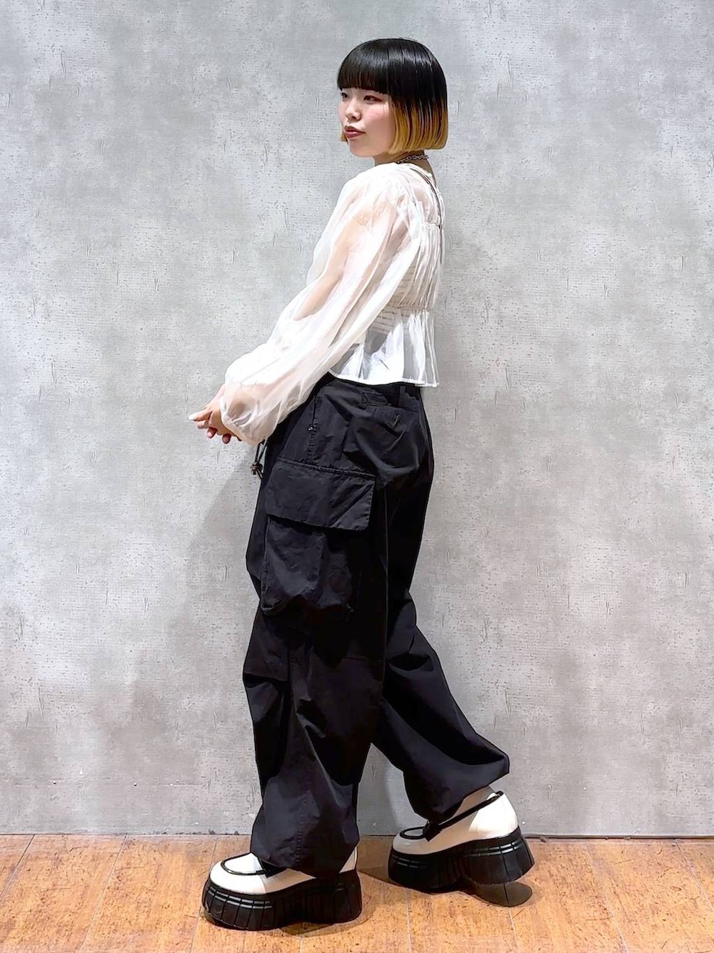ブラック系のカーゴパンツ、ホワイト系のシャツ/ブラウス、ブラック系のキャミソールを着用したレディースの春コーディネートの4枚目の写真