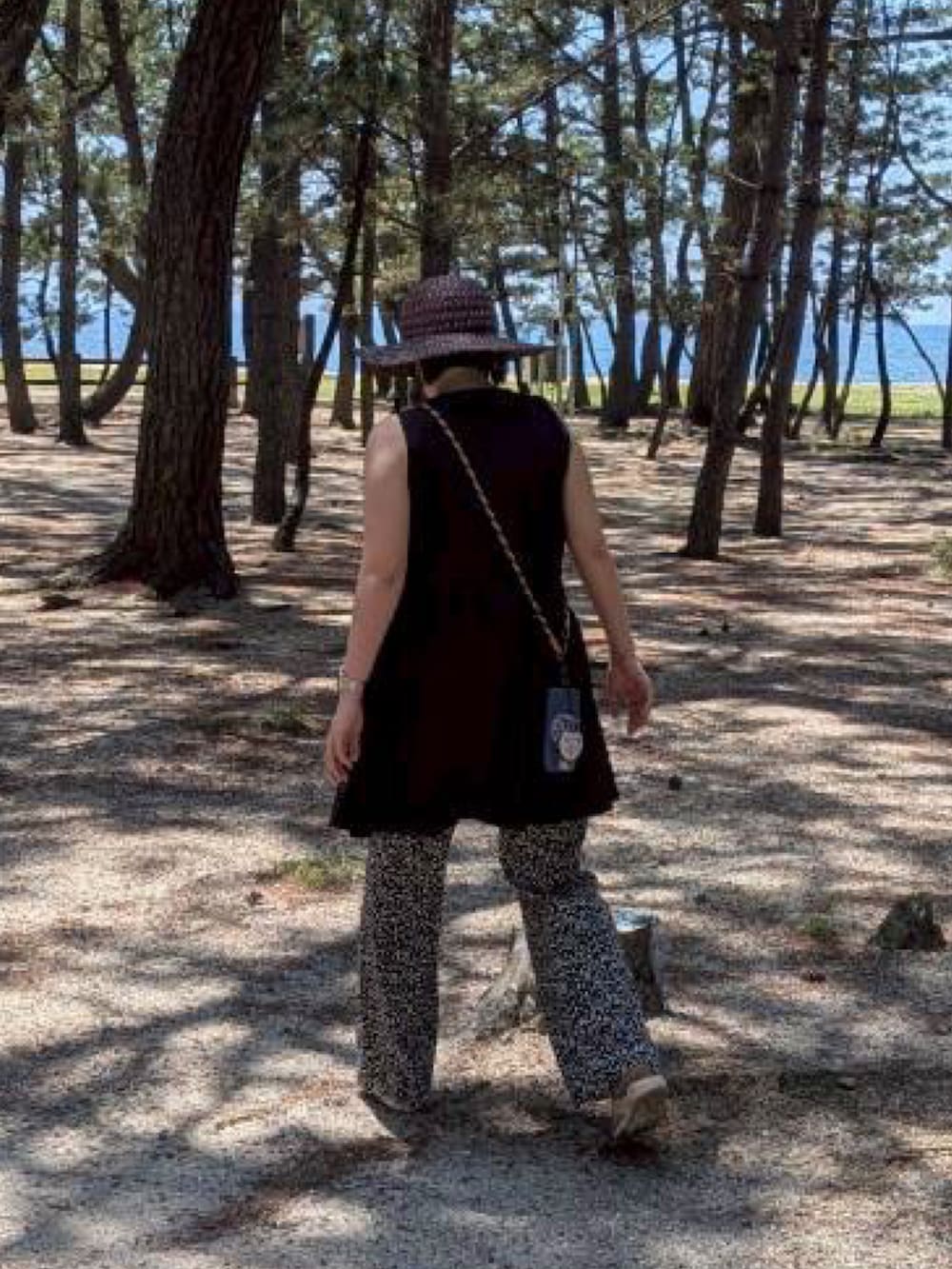 ブラック系のその他パンツ、ホワイト系のサンダル、その他のショルダーバッグを着用したレディースの夏コーディネートの2枚目の写真