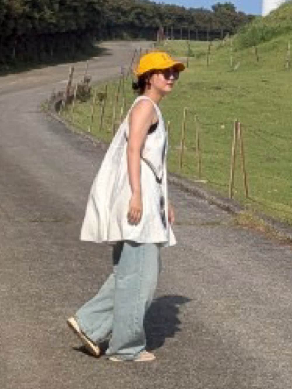 ブルー系のデニムパンツ、ホワイト系のワンピース/ドレス、ホワイト系のサンダルを着用したレディースの夏コーディネートの2枚目の写真