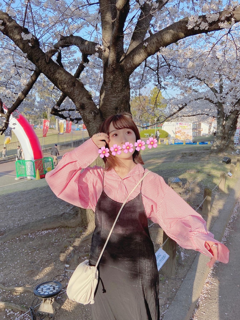 ブラック系のワンピース、ホワイト系のブーツ、ピンク系のトップスを着用したレディースの春コーディネートの3枚目の写真