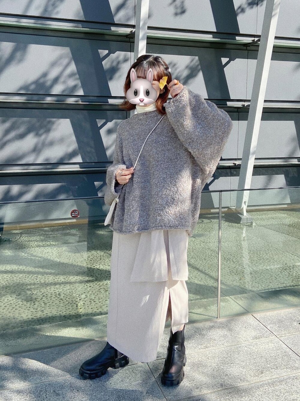 ブラウン系のニット/セーター、ベージュ系のスカート、ブラック系のブーツを着用したレディースの秋コーディネートの2枚目の写真