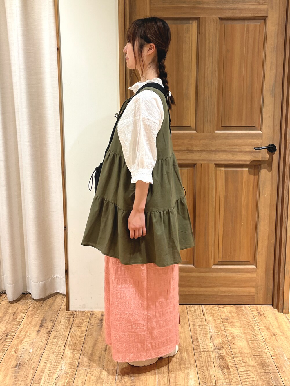 ベージュ系のドレスシューズ、レッド系のスカート、ブラック系のハンドバッグを着用したレディースの秋コーディネートの2枚目の写真