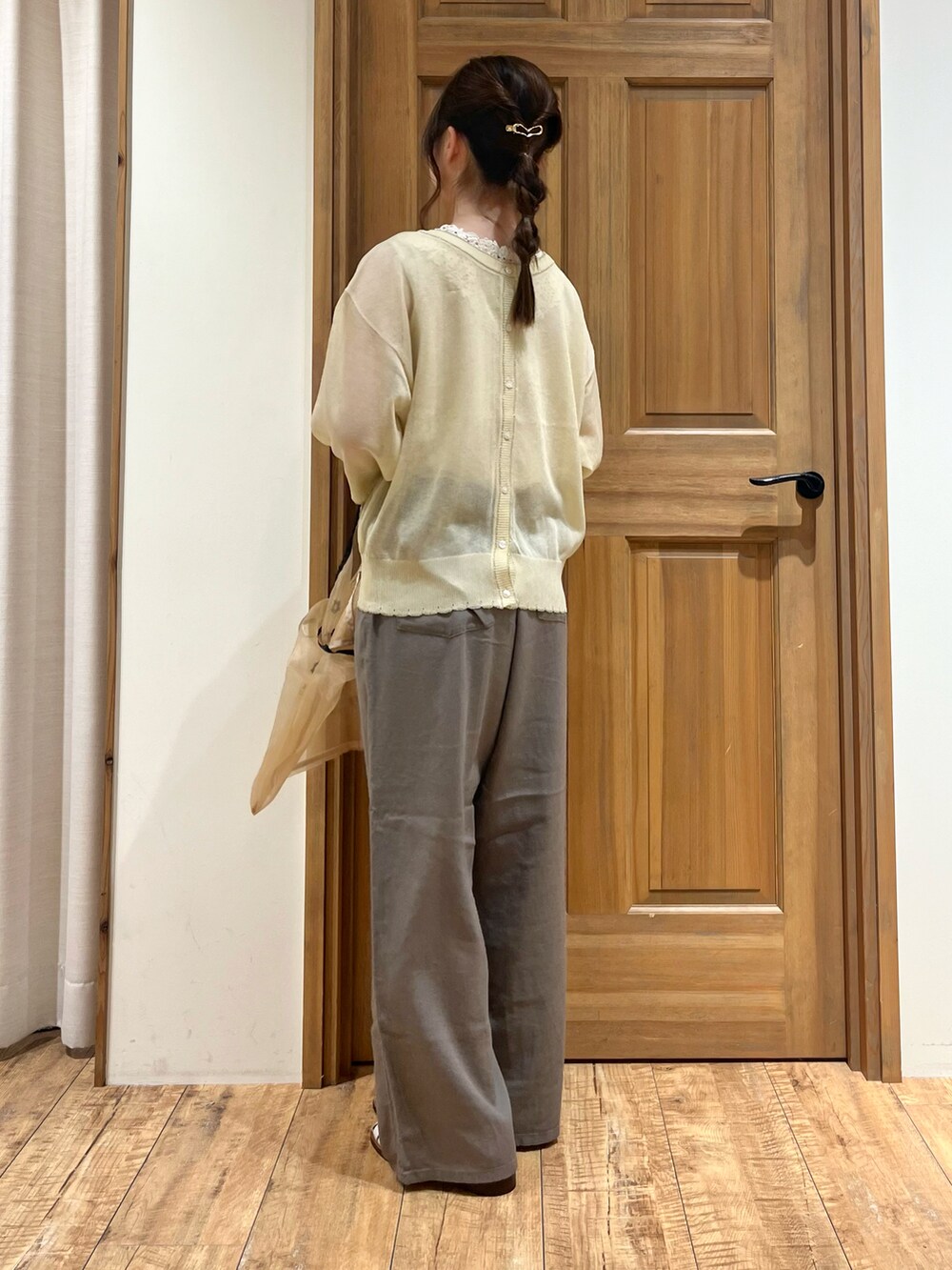 ベージュ系のハンドバッグ、ホワイト系のカーディガン/ボレロ、ホワイト系のタンクトップを着用したレディースの夏コーディネートの3枚目の写真