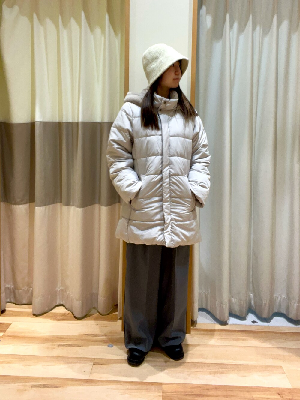 グレー系のその他パンツ、ブルー系のニット/セーター、ベージュ系のその他アウターを着用したレディースの秋コーディネートの2枚目の写真