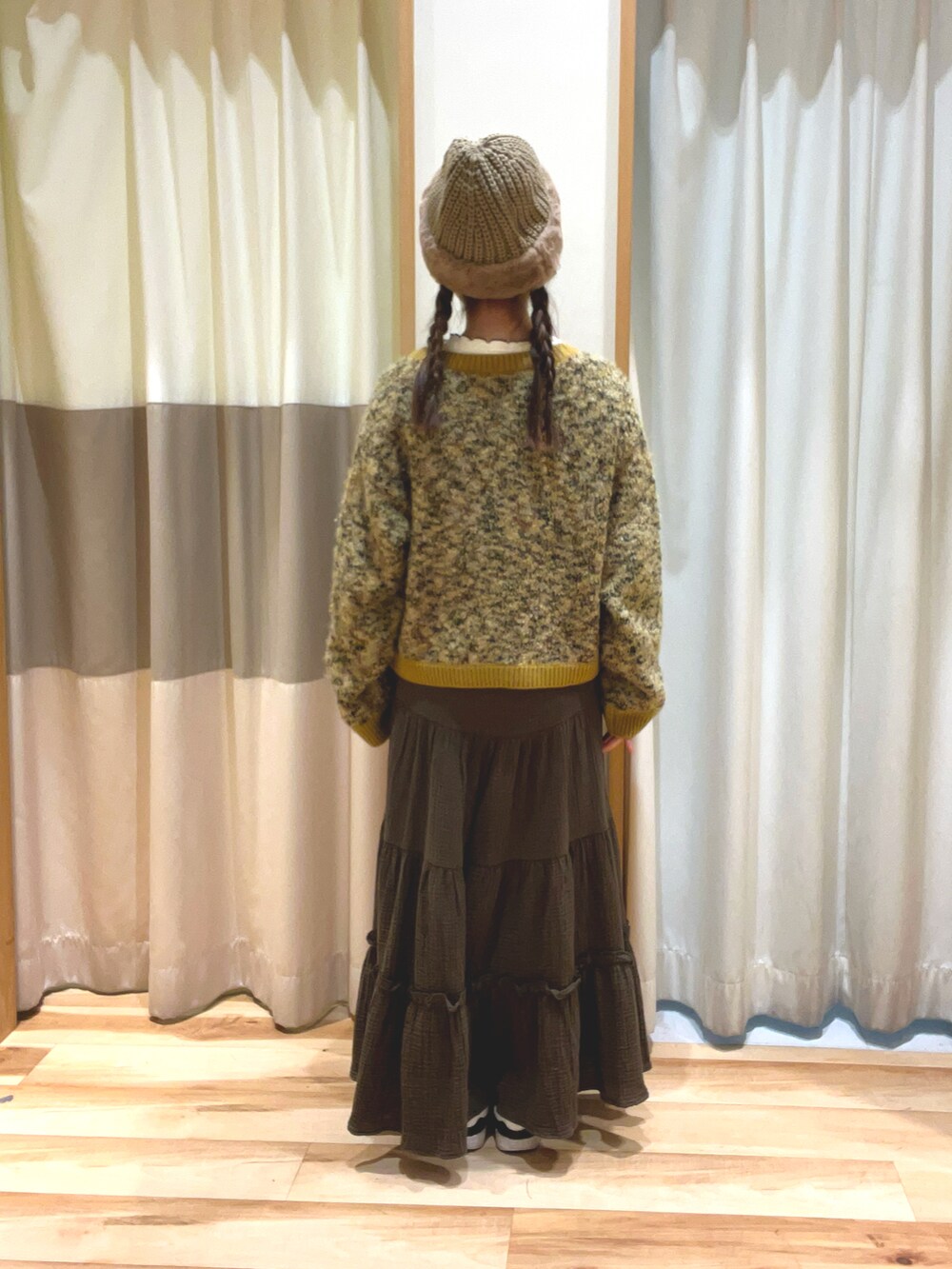 イエロー系のカーディガン/ボレロ、グリーン系のスカート、ホワイト系のTシャツ/カットソーを着用したレディースの冬コーディネートの4枚目の写真