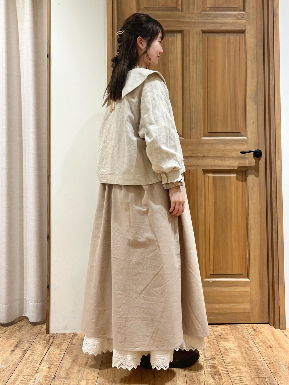 ブラウン系のブーツ、ブラウン系のハンドバッグ、ホワイト系のノーカラージャケットを着用したレディースの秋コーディネートの4枚目の写真