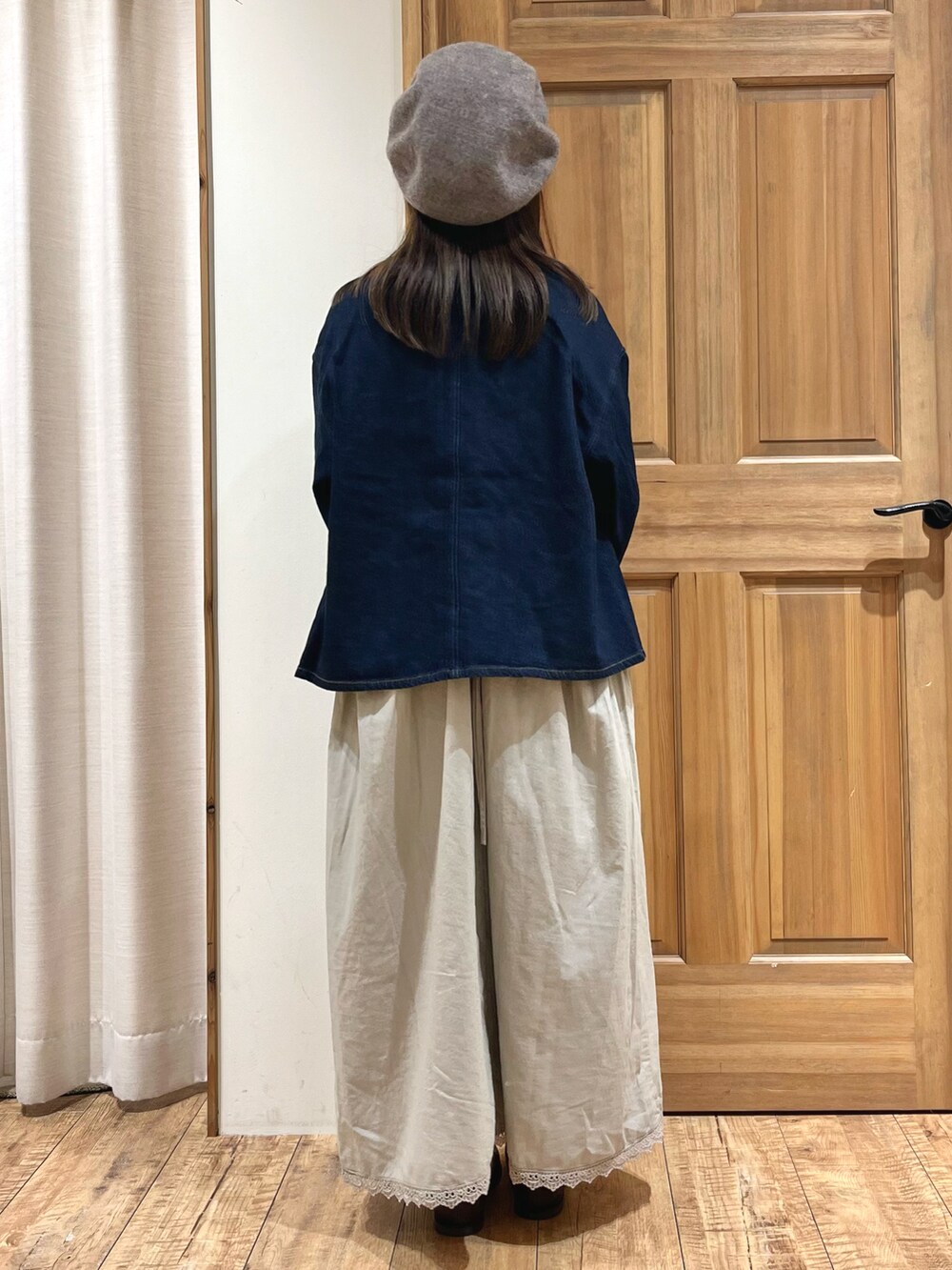 ブラウン系のドレスシューズ、ブルー系のノーカラージャケット、ベージュ系のワンピースを着用したレディースの秋コーディネートの4枚目の写真