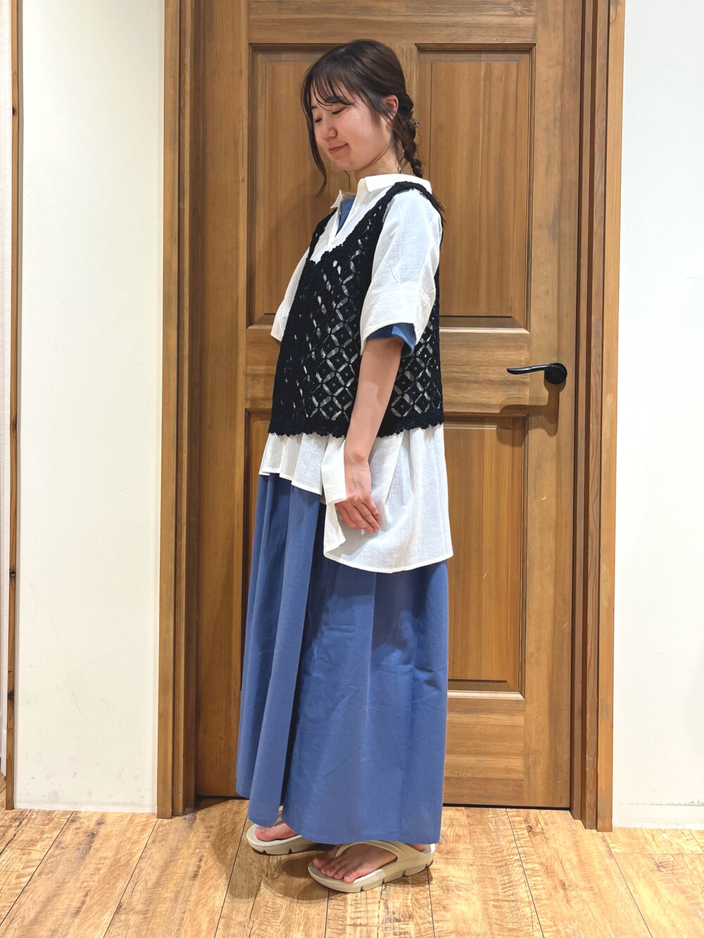 ホワイト系のサンダル、ブルー系のワンピース、ブラック系のベストを着用したレディースの夏コーディネートの2枚目の写真