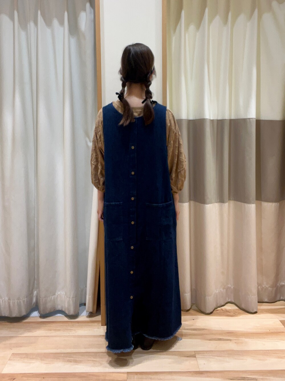 ベージュ系のTシャツ/カットソー、ブルー系のワンピース、ブラック系のハンドバッグを着用したレディースの秋コーディネートの3枚目の写真