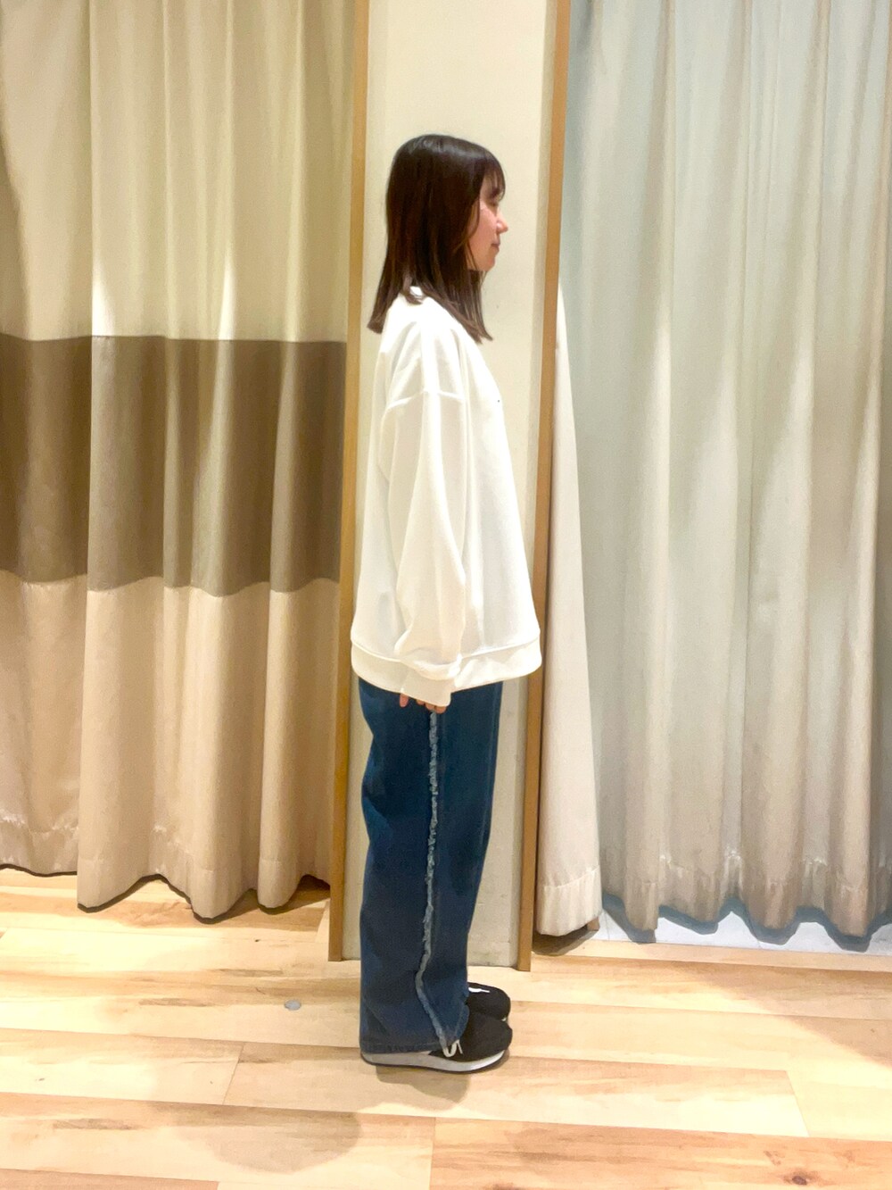 イエロー系のハンドバッグ、ブルー系のデニムパンツ、ホワイト系のTシャツ/カットソーを着用したレディースの春コーディネートの2枚目の写真