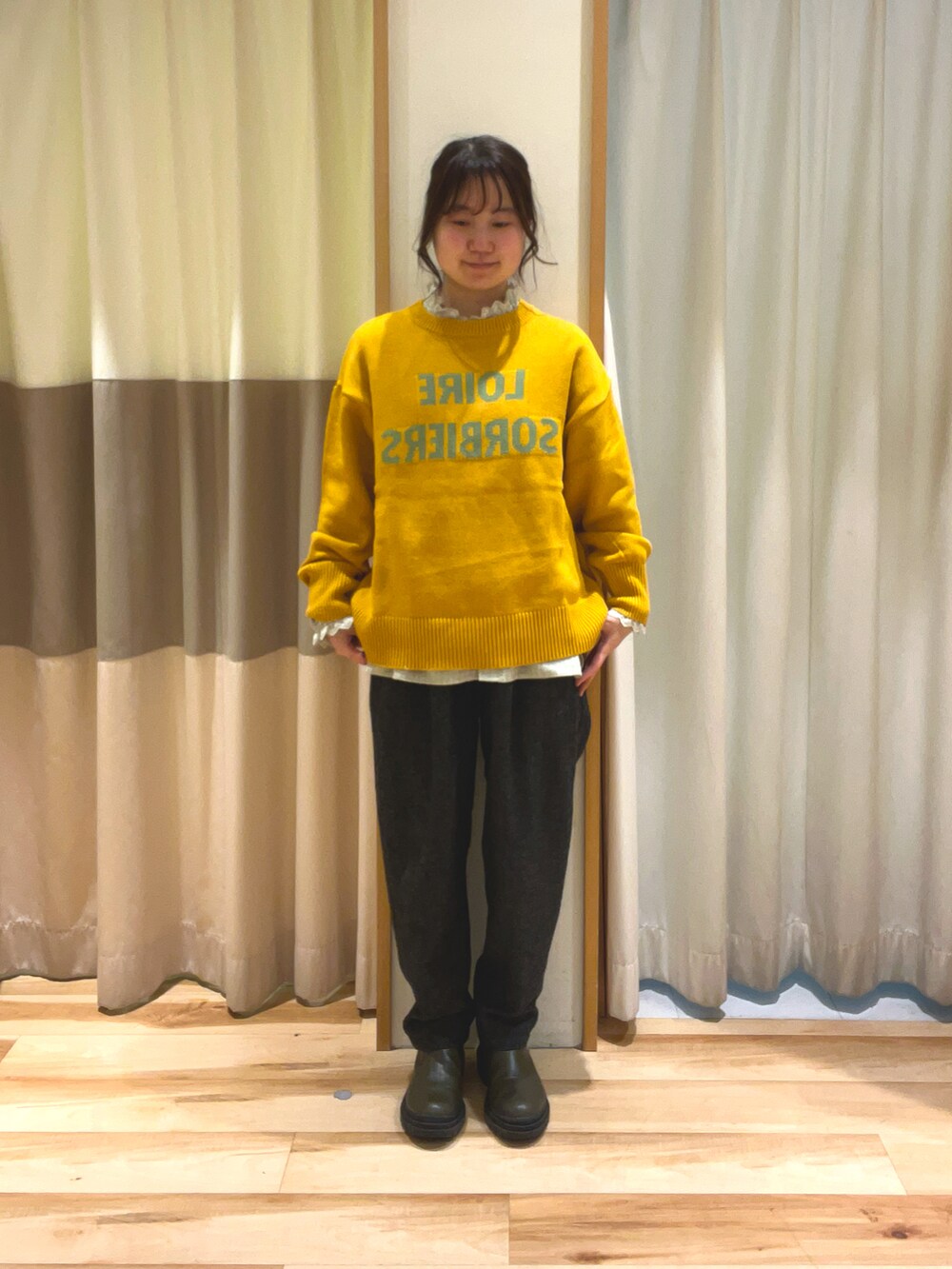 イエロー系のニット/セーター、グレー系のシャツ/ブラウス、グレー系のその他パンツを着用したレディースの冬コーディネートの2枚目の写真