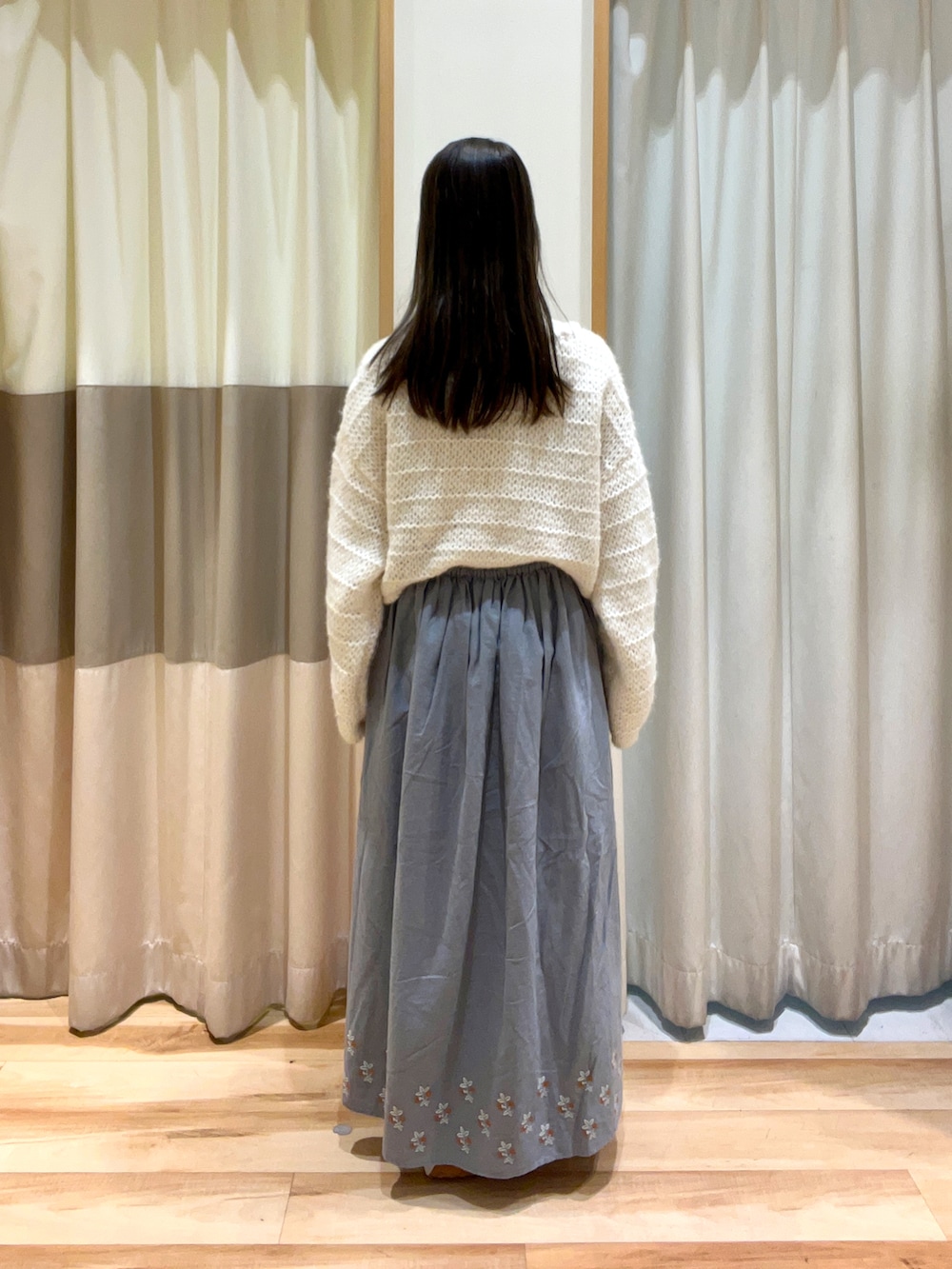 ホワイト系のTシャツ/カットソー、ホワイト系のニット/セーター、ブルー系のスカートを着用したレディースの秋コーディネートの3枚目の写真