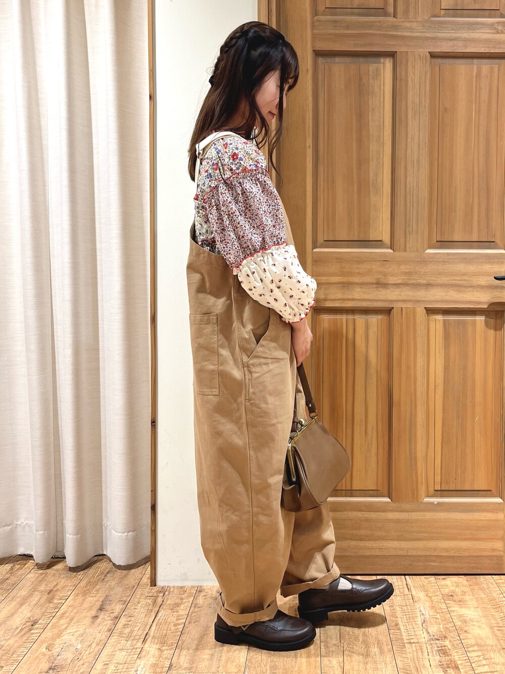 ブラウン系のハンドバッグ、ベージュ系のサロペット/オーバーオール、ホワイト系のシャツ/ブラウスを着用したレディースの秋コーディネートの5枚目の写真