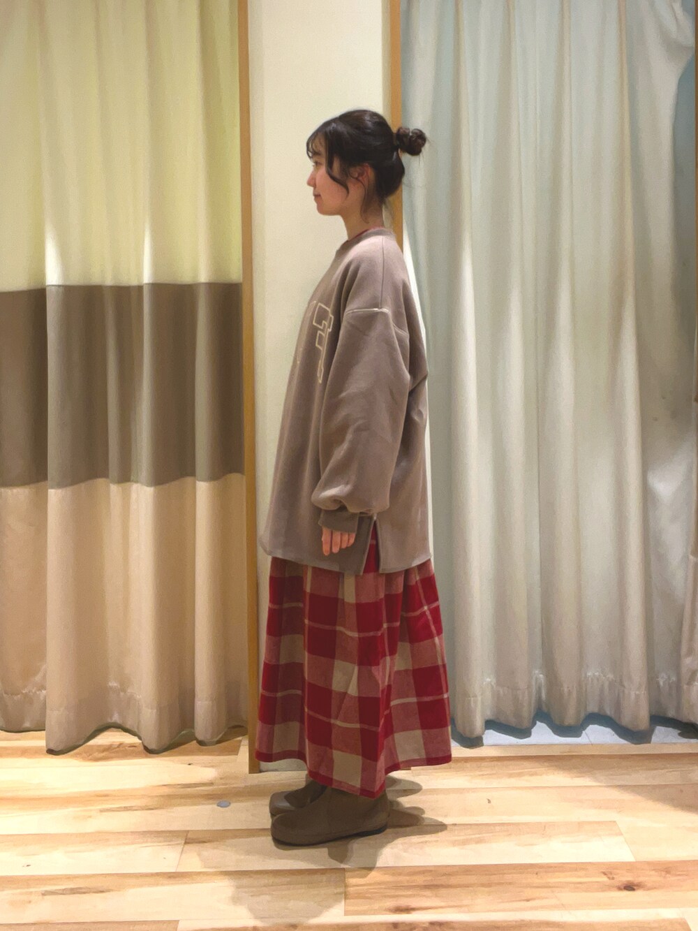 ブラウン系のTシャツ/カットソー、レッド系のワンピース、ベージュ系のブーツを着用したレディースの冬コーディネートの2枚目の写真