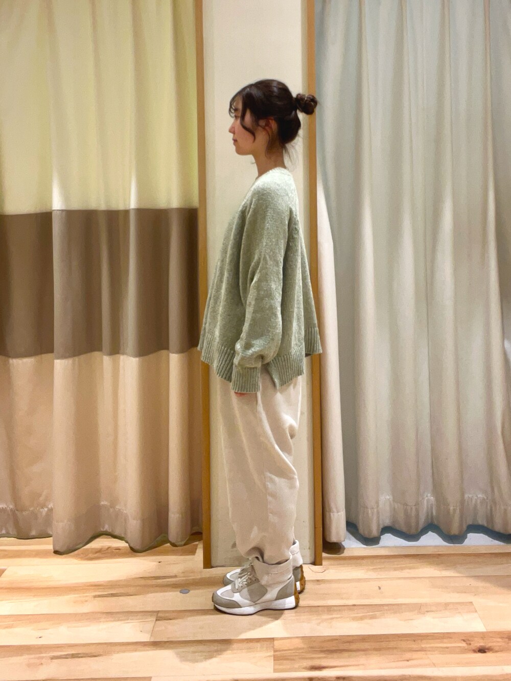 グリーン系のニット/セーター、ホワイト系のその他パンツを着用したレディースの冬コーディネートの3枚目の写真