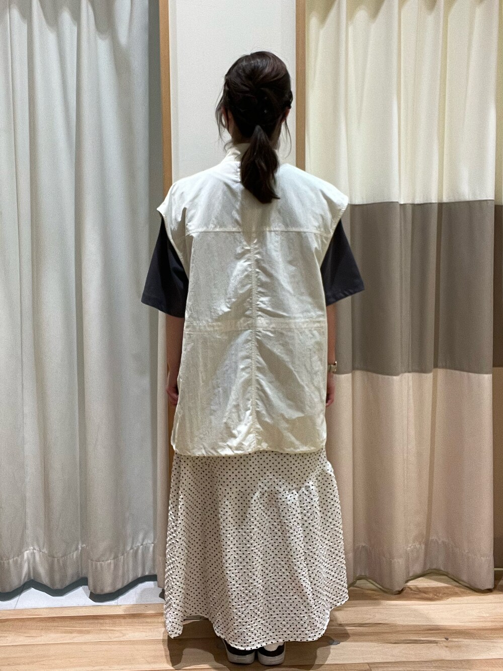 ホワイト系のベスト、グレー系のTシャツ/カットソー、ホワイト系のスカートを着用したレディースの春コーディネートの3枚目の写真