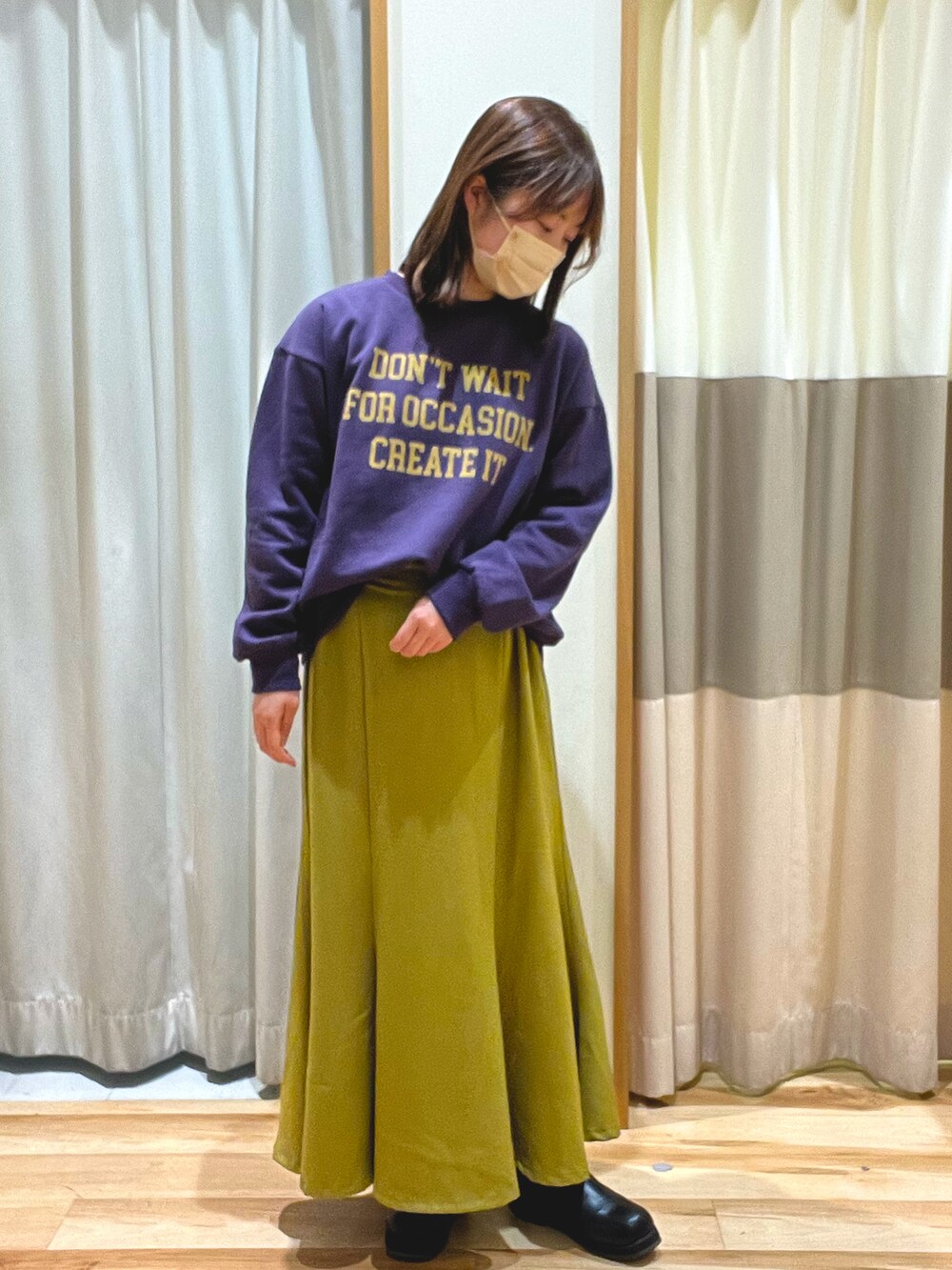 パープル系のTシャツ/カットソー、ホワイト系のマウンテンパーカー、イエロー系のスカートを着用したレディースの冬コーディネートの5枚目の写真