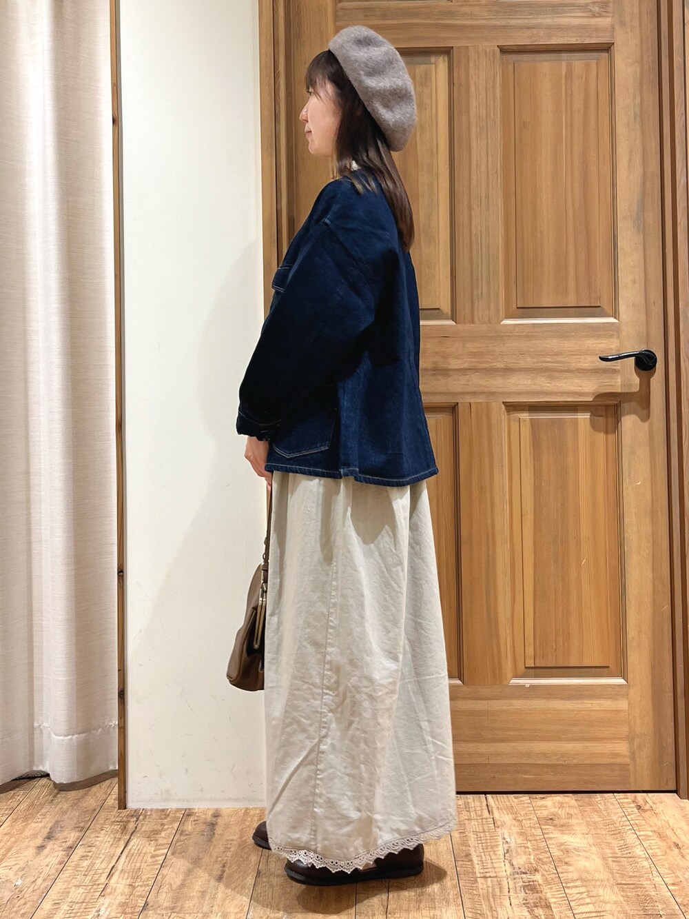 ブラウン系のドレスシューズ、ブルー系のノーカラージャケット、ベージュ系のワンピースを着用したレディースの秋コーディネートの3枚目の写真