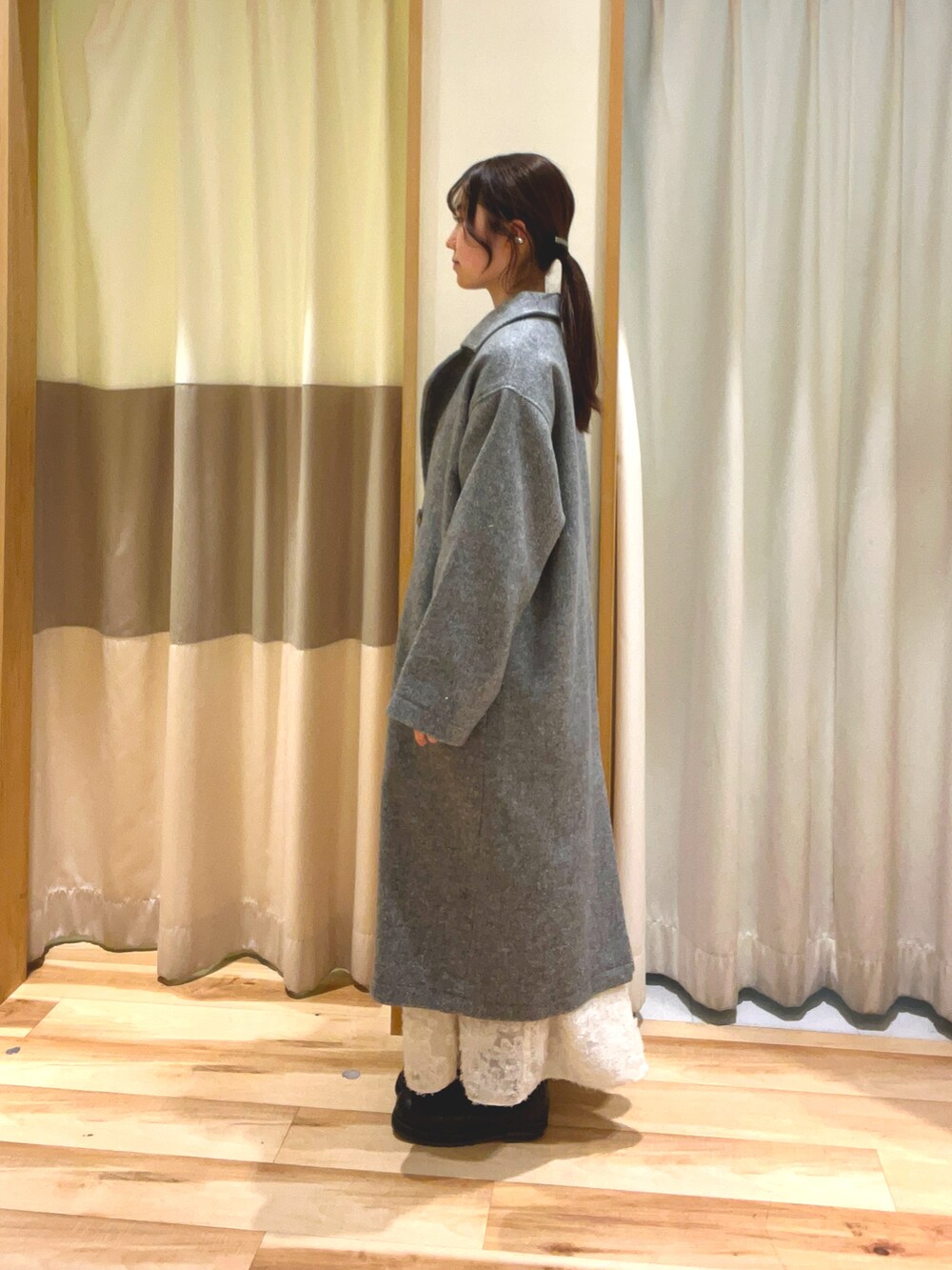 ブルー系のニット/セーター、ホワイト系のスカート、グレー系のその他アウターを着用したレディースの冬コーディネートの3枚目の写真