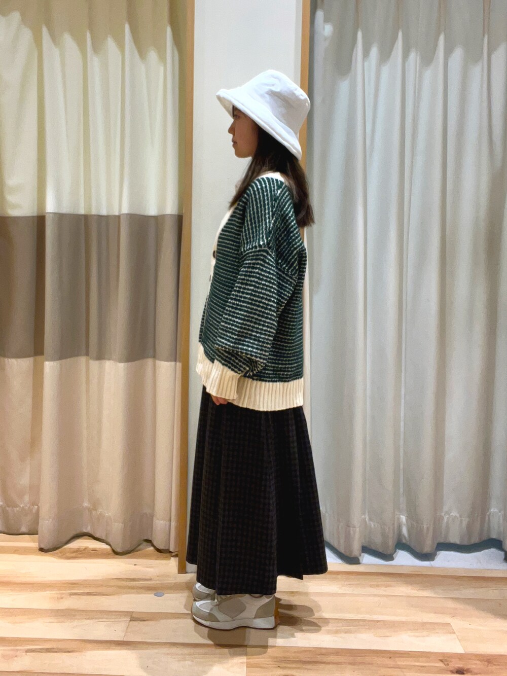 ホワイト系のシャツ/ブラウス、グリーン系のカーディガン/ボレロ、グレー系のスカートを着用したレディースの秋コーディネートの2枚目の写真