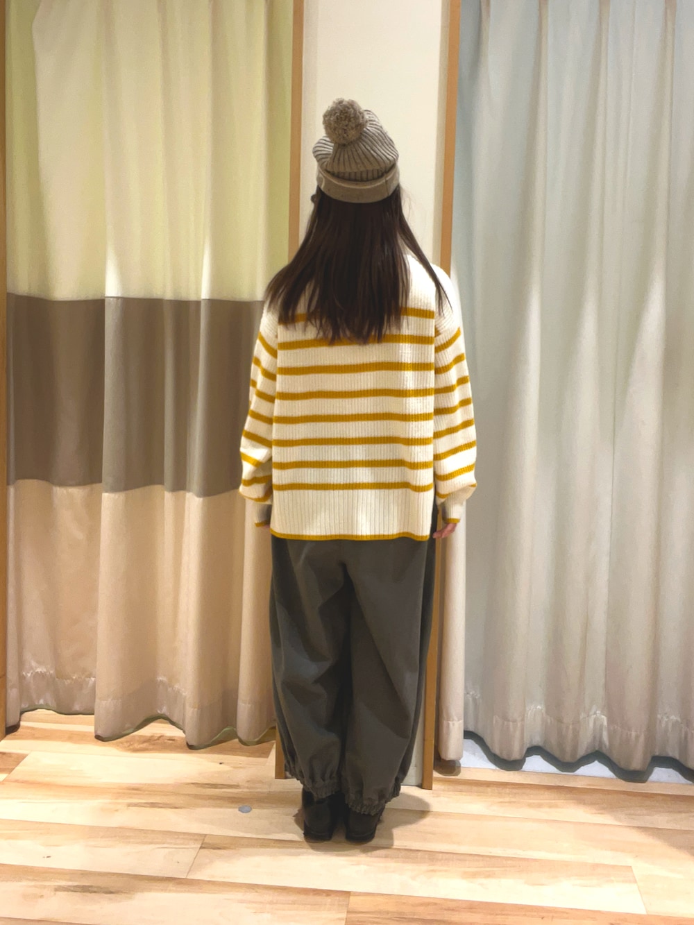 ブラウン系のその他パンツ、イエロー系のカーディガン/ボレロ、ブラウン系のニットキャップ/ビーニーを着用したレディースの冬コーディネートの4枚目の写真