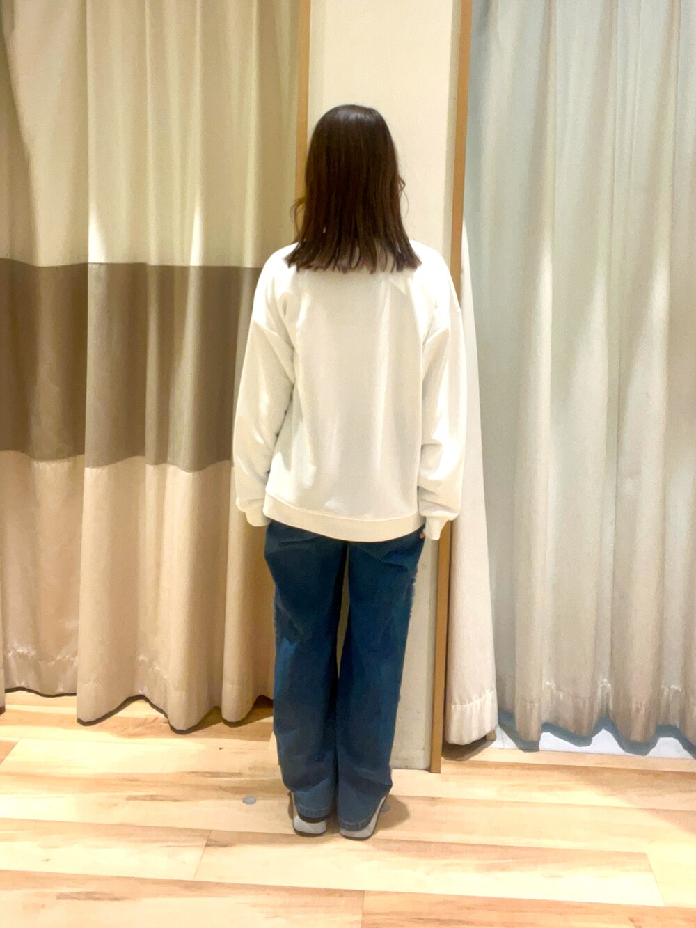 イエロー系のハンドバッグ、ブルー系のデニムパンツ、ホワイト系のTシャツ/カットソーを着用したレディースの春コーディネートの3枚目の写真