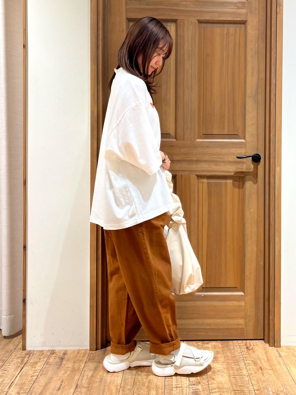 ベージュ系のサンダル、ブラウン系のその他パンツ、ホワイト系のTシャツ/カットソーを着用したレディースの夏コーディネートの2枚目の写真