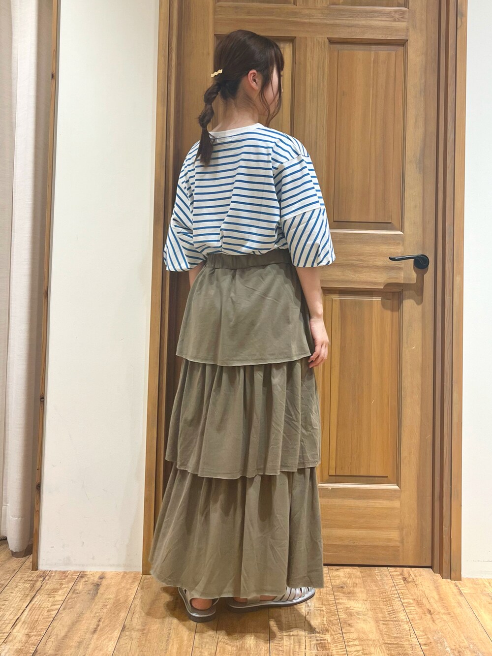 シルバー系のサンダル、ブルー系のTシャツ/カットソー、グリーン系のスカートを着用したレディースの夏コーディネートの3枚目の写真