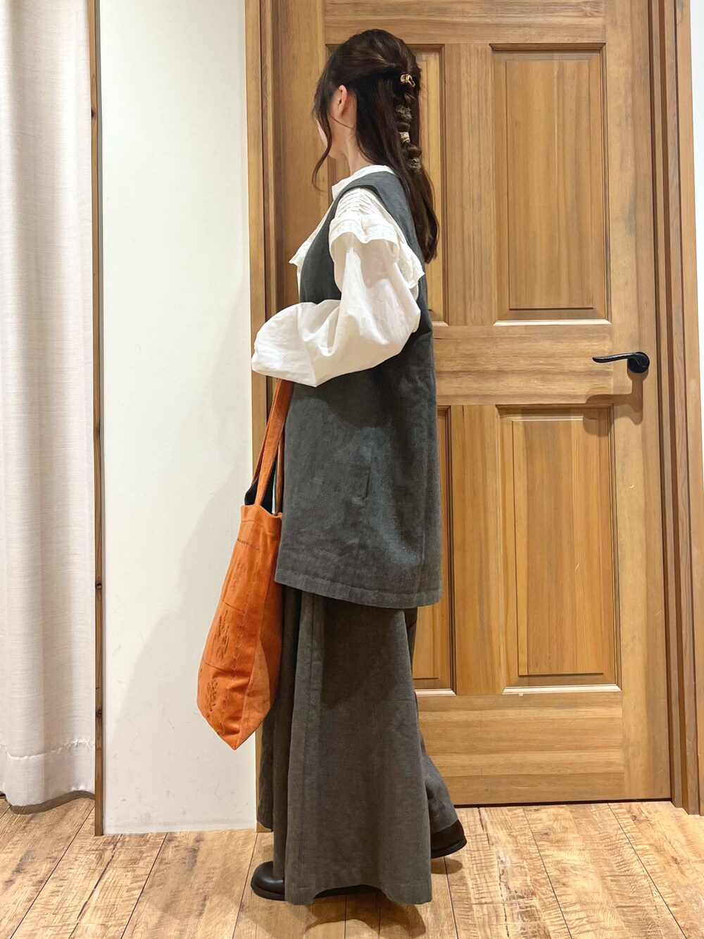 ブラック系のブーツ、ホワイト系のシャツ/ブラウス、ブラック系のベストを着用したレディースの秋コーディネートの3枚目の写真