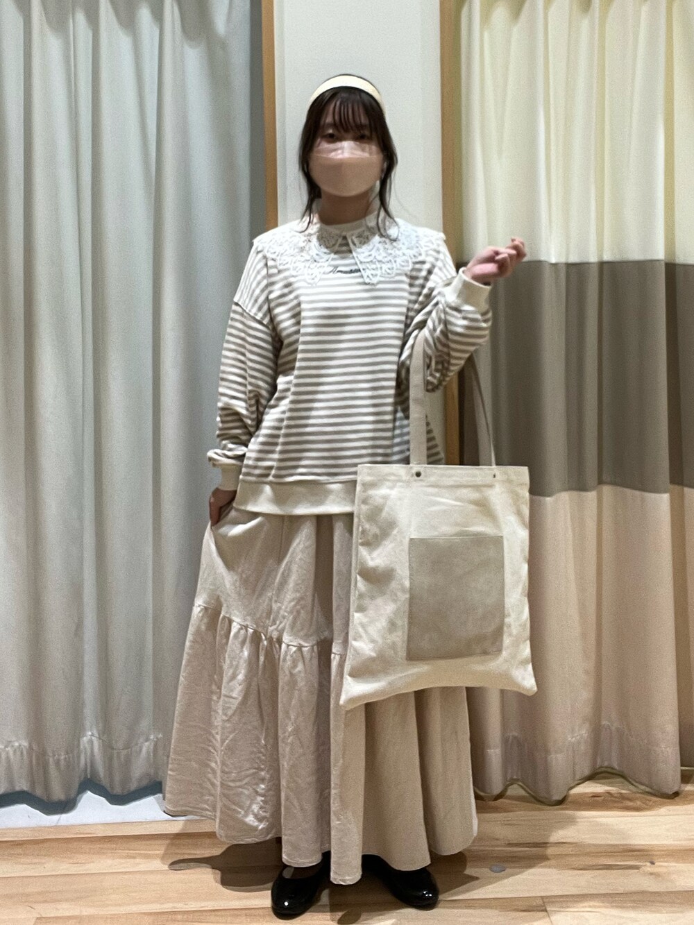 ホワイト系のニット/セーター、ベージュ系のハンドバッグ、ホワイト系のスカートを着用したレディースの冬コーディネートの2枚目の写真