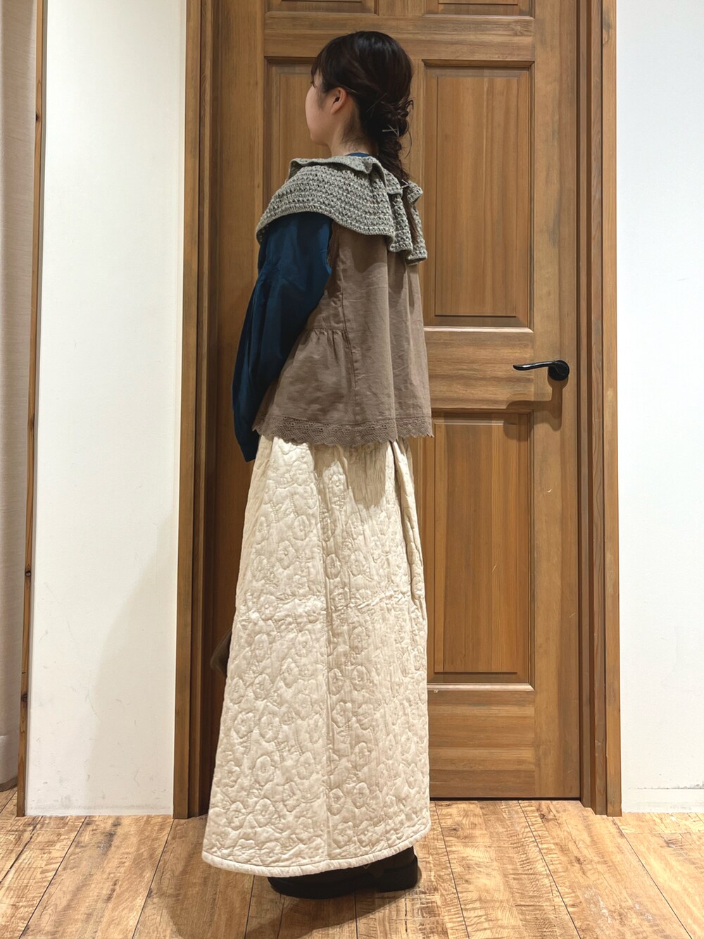 ブラウン系のハンドバッグ、ブラウン系のベスト、ブルー系のシャツ/ブラウスを着用したレディースの秋コーディネートの3枚目の写真