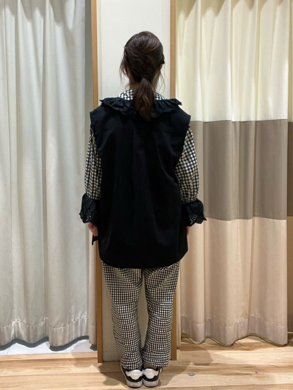 グレー系のシャツ/ブラウス、ブラック系のベスト、ホワイト系のその他パンツを着用したレディースの春コーディネートの4枚目の写真