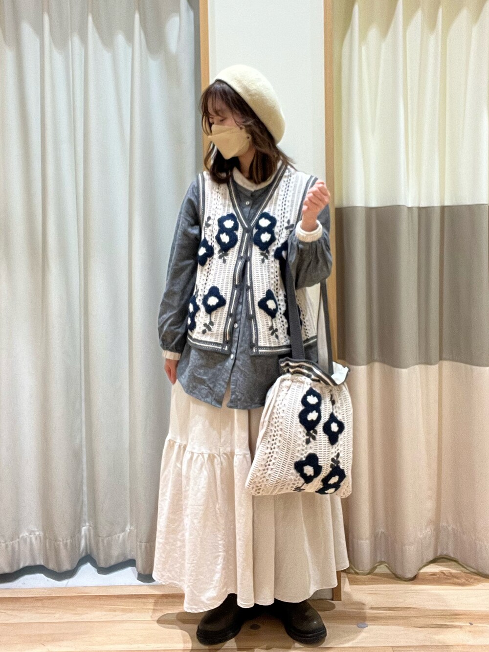 グレー系のシャツ/ブラウス、ホワイト系のベスト、ホワイト系のバッグを着用したレディースの冬コーディネートの2枚目の写真