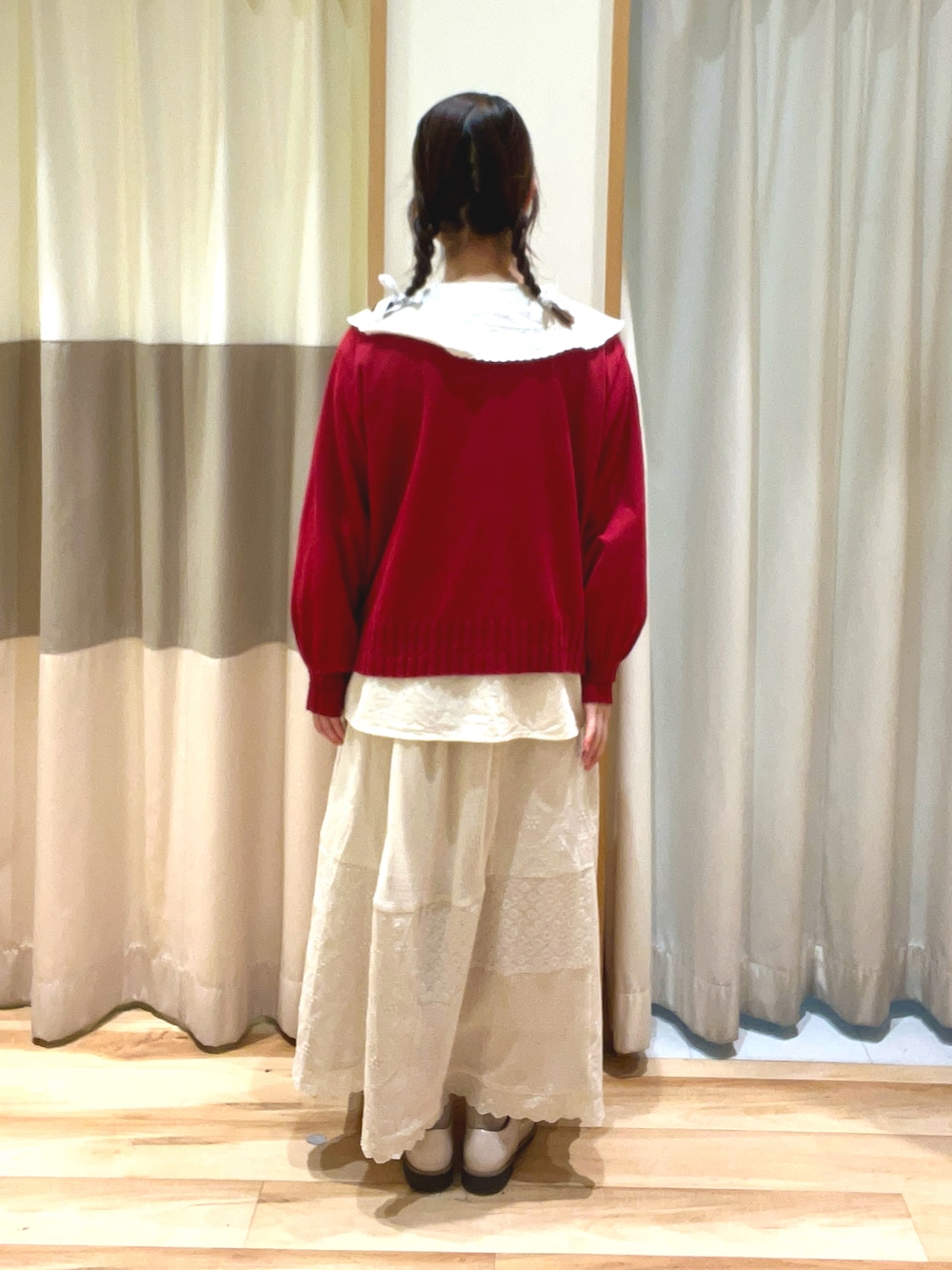 レッド系のカーディガン/ボレロ、ホワイト系のシャツ/ブラウス、ホワイト系のスカートを着用したレディースの春コーディネートの4枚目の写真