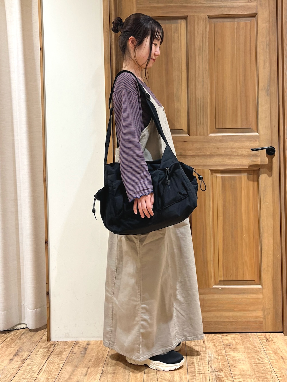 ブラック系のドレスシューズ、ブラック系のハンドバッグ、ベージュ系のワンピースを着用したレディースの秋コーディネートの3枚目の写真