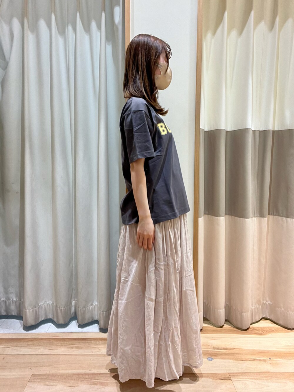 グレー系のTシャツ/カットソー、ホワイト系のハンドバッグ、グレー系のスカートを着用したレディースの春コーディネートの3枚目の写真