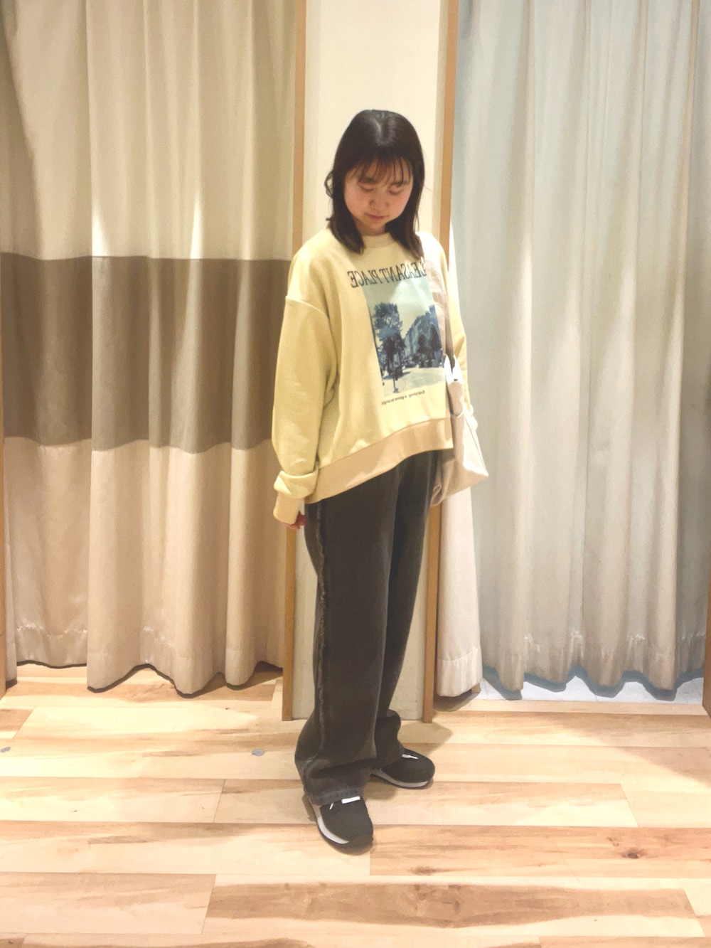 グレー系のデニムパンツ、ホワイト系のハンドバッグ、ベージュ系のTシャツ/カットソーを着用したレディースの春コーディネートの2枚目の写真