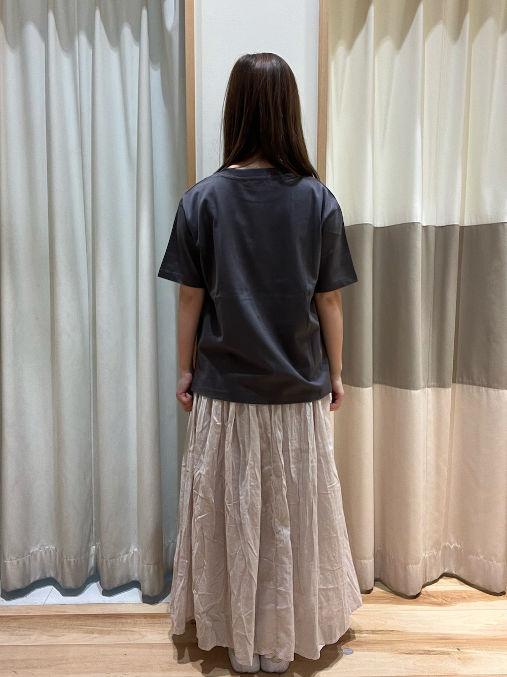 グレー系のTシャツ/カットソー、ホワイト系のハンドバッグ、グレー系のスカートを着用したレディースの春コーディネートの4枚目の写真